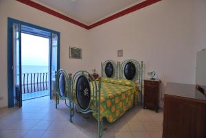 a bedroom with a bed and a balcony with the ocean at Oasi 2 terrace overlooking the sea in Canneto in Canneto - Lipari