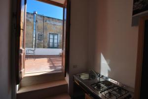 a kitchen with a stove and a view of a balcony at Oasi 2 terrace overlooking the sea in Canneto in Canneto - Lipari +10 photos