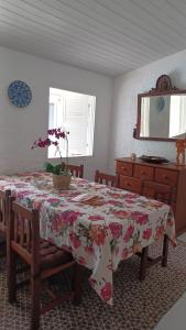 een eettafel met een bloementafel erop bij casa dos MORAIS in Angra dos Reis