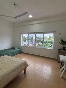 a bedroom with a bed and a large window at Centrico departamento en el corazon de Cancun a 5 mins del ADO in Cancún