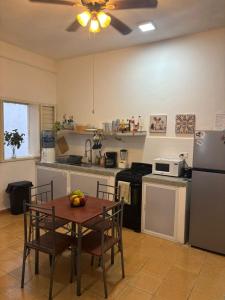 a kitchen with a table with chairs and a refrigerator at Centrico departamento en el corazon de Cancun a 5 mins del ADO in Cancún