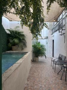 a courtyard with a pool and tables and plants at Centrico departamento en el corazon de Cancun a 5 mins del ADO in Cancún