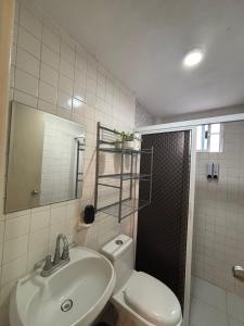 a bathroom with a sink and a toilet and a shower at Centrico departamento en el corazon de Cancun a 5 mins del ADO in Cancún