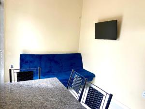 a living room with a blue couch and a tv at Apto Flat in Belém