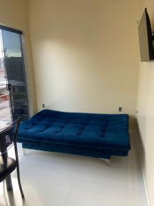 a blue couch in a room with a window at Apto Flat in Belém +5 photos