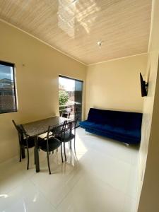 a living room with a table and a blue couch at Apto Flat in Belém