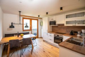 a kitchen with white cabinets and a wooden table at Urlpoldhof in Schladming