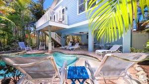 ein Haus mit einem Pool und zwei Gartenstühlen in der Unterkunft Beach Breezes in Anna Maria Island