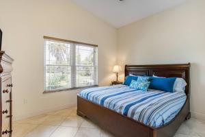 ein Schlafzimmer mit einem Bett mit blauen Kissen und einem Fenster in der Unterkunft Beach Breezes in Anna Maria Island + 23 Fotos