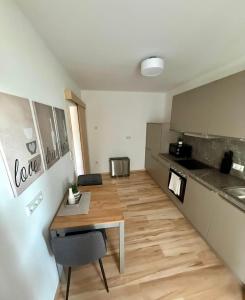 a kitchen with a wooden table in a room at Lichtblick in Goldbach +2 photos