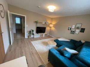ein Wohnzimmer mit einer blauen Couch und einem Fernseher in der Unterkunft Lichtblick in Goldbach