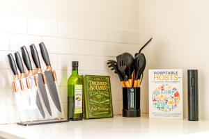 a kitchen counter with a bottle of wine and knives at Jungle House Chillicothe Sleeps 24 Downtown Ohio Free Parking - Walk to Historic District - 5BR Luxury Home - Pet Friendly - King Beds - Over 5,800 Five Star Stays in Chillicothe