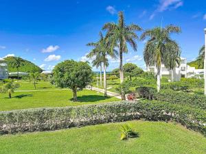 Un parque con palmeras y un edificio. en Case à Sucre Peaceful retreat with sea view and beach direct access, en Anse Marcel 