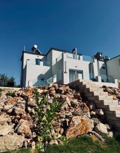 a building on top of a pile of rocks at Villa & Apartament Armonia 3 Gaja Flora Gavalochori - Vamos KRETA in Vamos