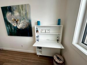 a white shelf in a room with a painting at Golden Moments in Golden