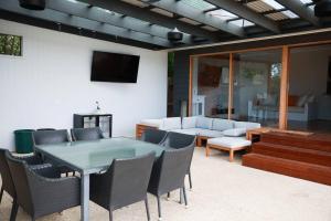 Grove Retreat With Pool, Sauna and Family Fun في Grovedale: فناء مع طاولة وكراسي وأريكة