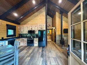 a kitchen with wooden floors and a black refrigerator at Explorer Creekside Cabin - Private Hot Tub in Golden