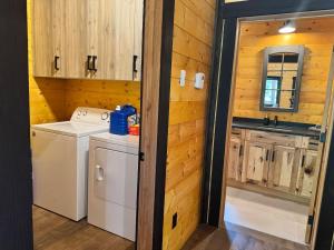 a kitchen with a washer and dryer in a cabin at Mountaineer Creekside Cabin - Private Hot Tub in Golden +24 photos