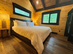 a bedroom with a bed in a wooden cabin at Mountaineer Creekside Cabin - Private Hot Tub in Golden