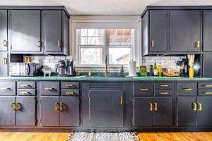 a kitchen with black cabinets and green counter tops at Jungle House Chillicothe Sleeps 24 Downtown Ohio Free Parking - Walk to Historic District - 5BR Luxury Home - Pet Friendly - King Beds - Over 5,800 Five Star Stays in Chillicothe