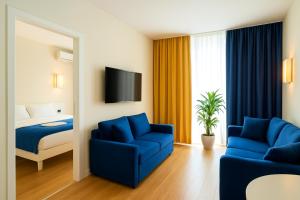 una camera d'albergo con un letto e due sedie blu di Elite Class Sea View Aparthotel In Orbi City Batumi a Batumi