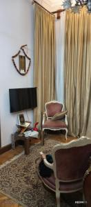 un soggiorno con 2 sedie e una TV di Tahrier square down town 51 El falki st Besaid usa university floor tow house number 10 a Il Cairo Altre 13 foto