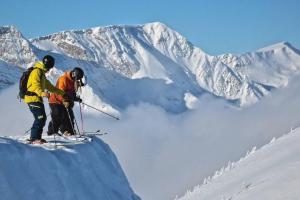 two people standing on top of a snow covered mountain at Explorer Creekside Cabin - Private Hot Tub in Golden