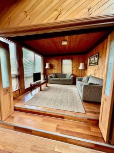 a living room with two couches and a tv at The Moona Cabin - Barwon Heads in Barwon Heads