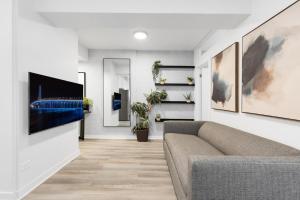 a living room with a couch and a tv on a wall at The Sherbrooke Suite in Montreal