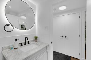 a white bathroom with a sink and a mirror at The Sherbrooke Suite 101 in Montreal