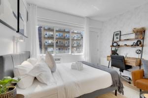 a bedroom with a bed and a chair and a window at The Sherbrooke Suite 99 in Montreal
