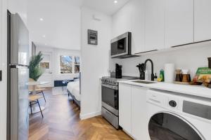 a white kitchen with a stove and a sink at The Speakeasy Suite 502 With Parking in Montreal