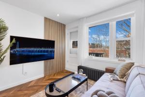 a living room with a couch and a flat screen tv at The Speakeasy Suite 502 With Parking in Montreal