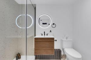 a bathroom with a sink and a toilet and a mirror at The Speakeasy Suite 502 With Parking in Montreal +14 photos