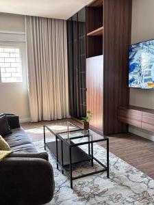 a living room with a couch and a glass coffee table at استوديو فندقي in An Nikāshah