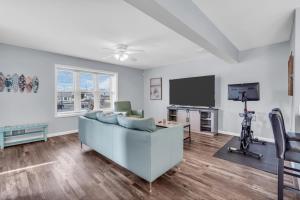 a living room with a couch and a tv at Seaside Park Beach Home 3BR w Deck Peloton Parking 6 Beach Passes in Seaside Park