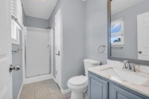 a white bathroom with a toilet and a sink at Seaside Park Beach Home 3BR w Deck Peloton Parking 6 Beach Passes in Seaside Park +13 photos