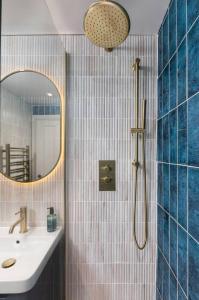 Un baño con lavabo y ducha con espejo. en Modern 1-Bed Retreat by Stirling Train Station, en Stirling