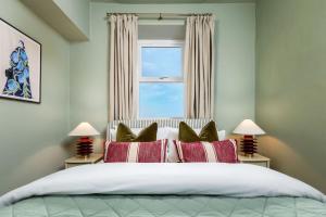 Un dormitorio con una cama grande con ventana. en Modern 1-Bed Retreat by Stirling Train Station, en Stirling