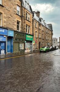 Una calle vacía de la ciudad con edificios y un coche verde. en Modern 1-Bed Retreat by Stirling Train Station, en Stirling