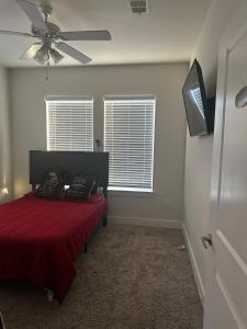a bedroom with a red bed with a ceiling fan at Southside 3bed 2Ba Spacious Comfy Home in Fort Worth