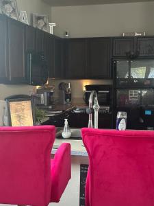 a kitchen with pink chairs in front of a counter at Southside 3bed 2Ba Spacious Comfy Home in Fort Worth