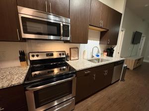 una cocina con estufa y microondas en The Nash Luxe, Pool, Gym, Nightlife!, en Nashville