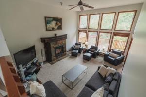 ein Wohnzimmer mit Sofa und Stühlen und einem Kamin in der Unterkunft Chesterman on the Point - Beachfront in Tofino