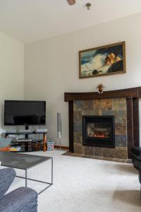 a living room with a fireplace and a tv at Chesterman on the Point - Beachfront in Tofino