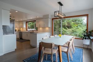 a kitchen with a white table and chairs at Chesterman on the Point - Beachfront in Tofino +52 photos
