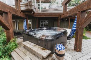 a jacuzzi tub on a wooden deck at Chesterman on the Point - Beachfront in Tofino