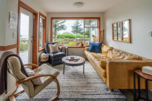 a living room with a couch and a table at Chesterman on the Point - Beachfront in Tofino