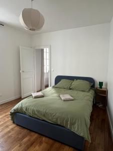 a bedroom with a large bed with two pillows on it at L'Ecrin Bellifontain - Appartement Confort - Centre in Fontainebleau
