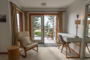 ein Wohnzimmer mit Schreibtisch und Stuhl in der Unterkunft Chesterman on the Point - Beachfront in Tofino